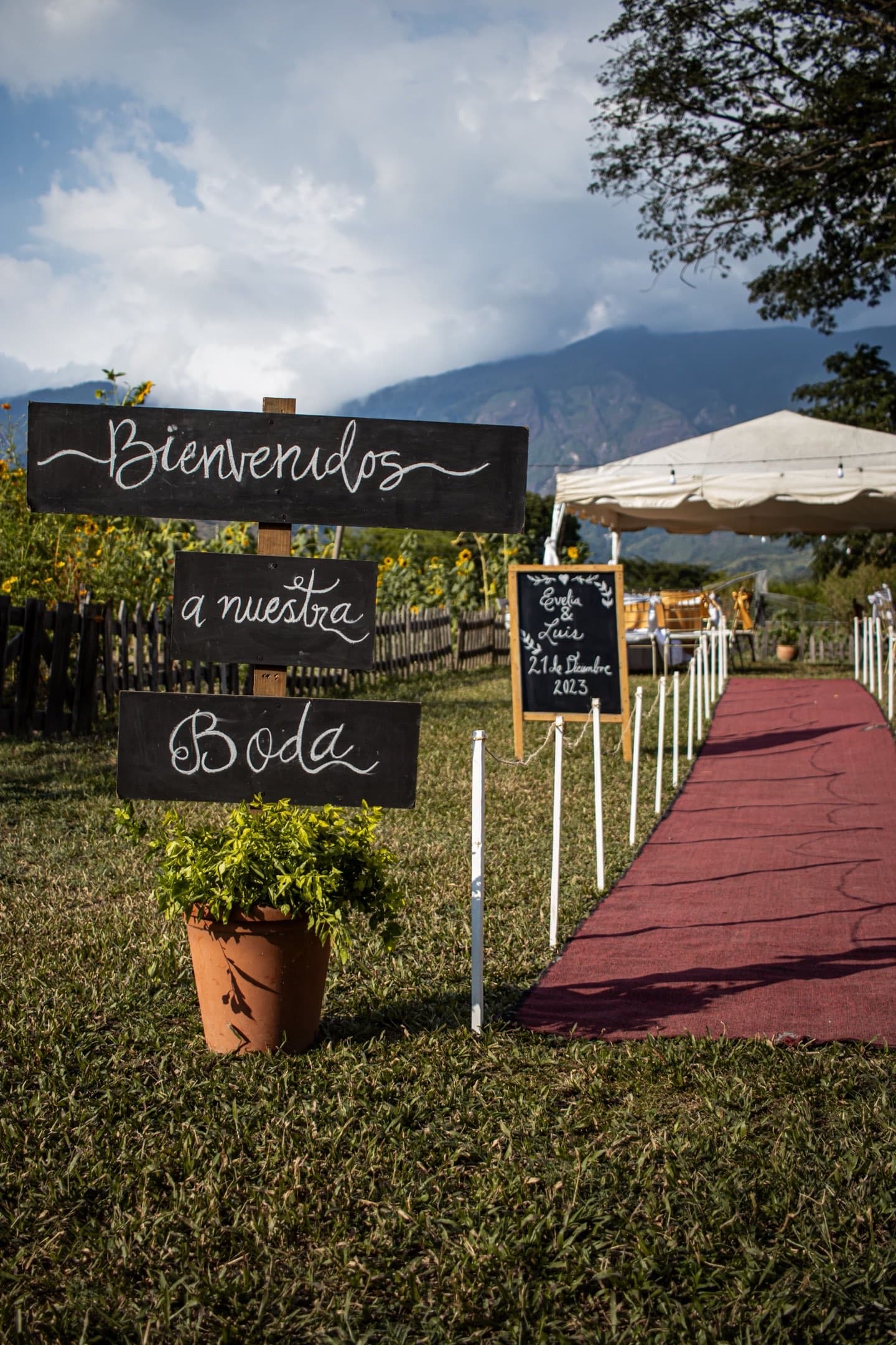 Stock photograph of a Spanish welcome sign beside an outdoor wedding aisle