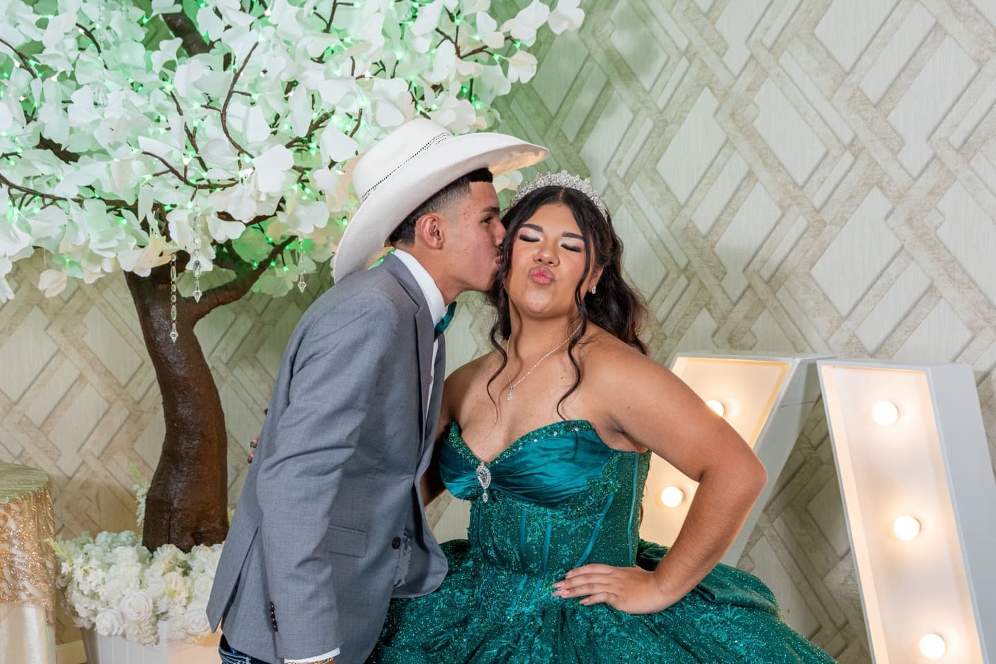 Stock photograph of a quinceañera in a green gown with a guest at her celebration